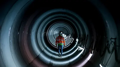 Mann läuft durch Tunnel.