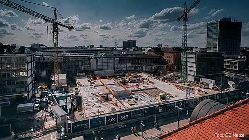 Kräne am Rand einer Baustelle.