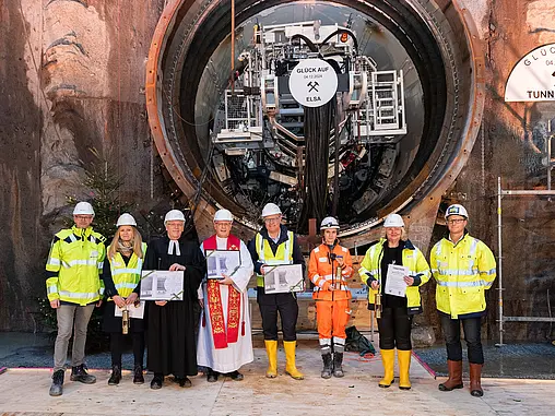 Mehrere Personen stehen vor der Öffnung eines Tunnels.