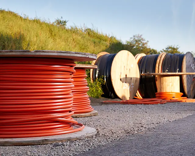 Große Rollen mit roten Kabeln für den Breitbandausbau.
